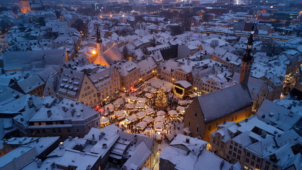 A captivating aerial view of Tallinn's snowy Christmas Market in Old Town square.