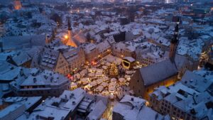 A captivating aerial view of Tallinn's snowy Christmas Market in Old Town square.