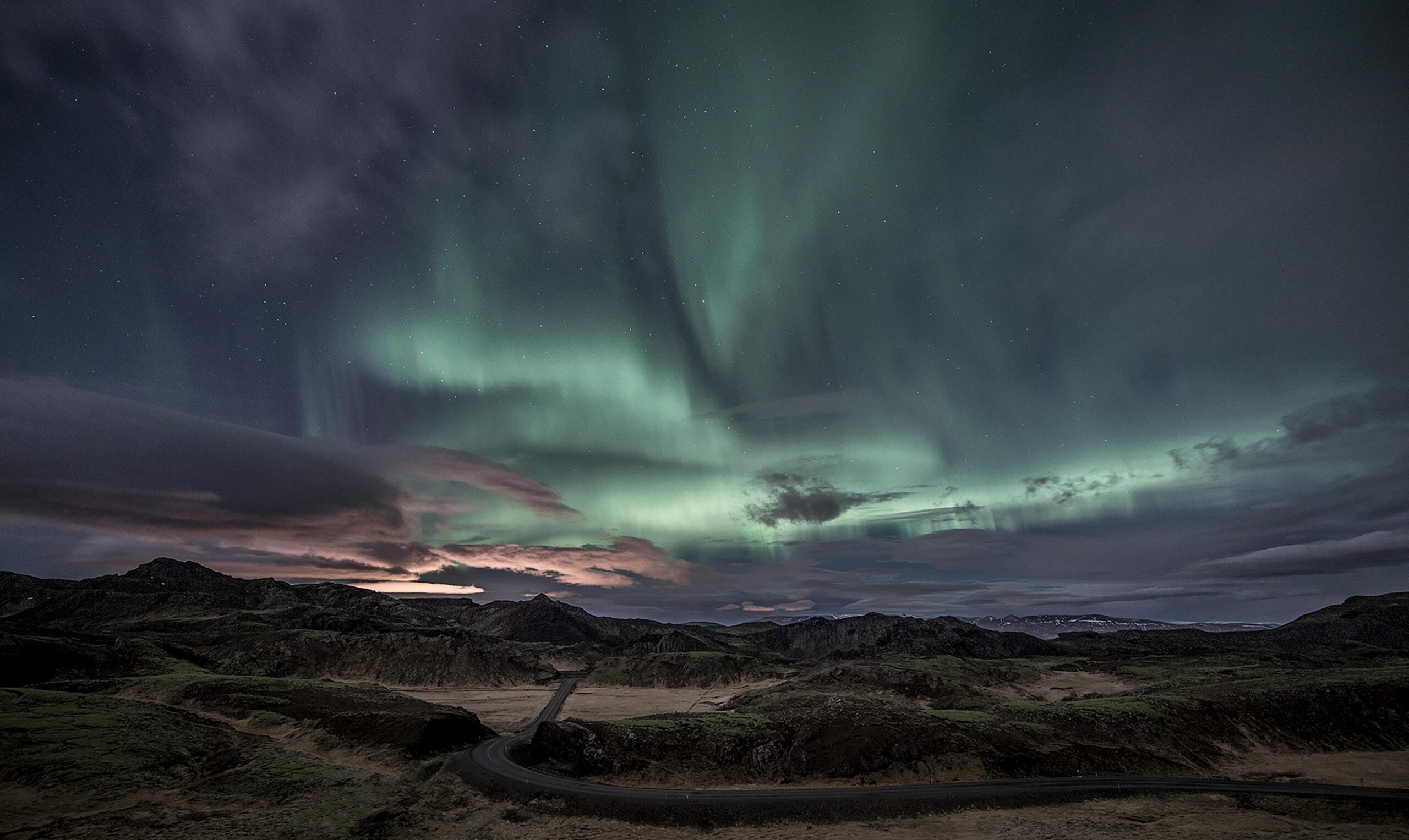 Stunning view of the Northern Lights illuminating Iceland's rugged terrain at night.