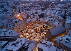A captivating aerial view of Tallinn's snowy Christmas Market in Old Town square.